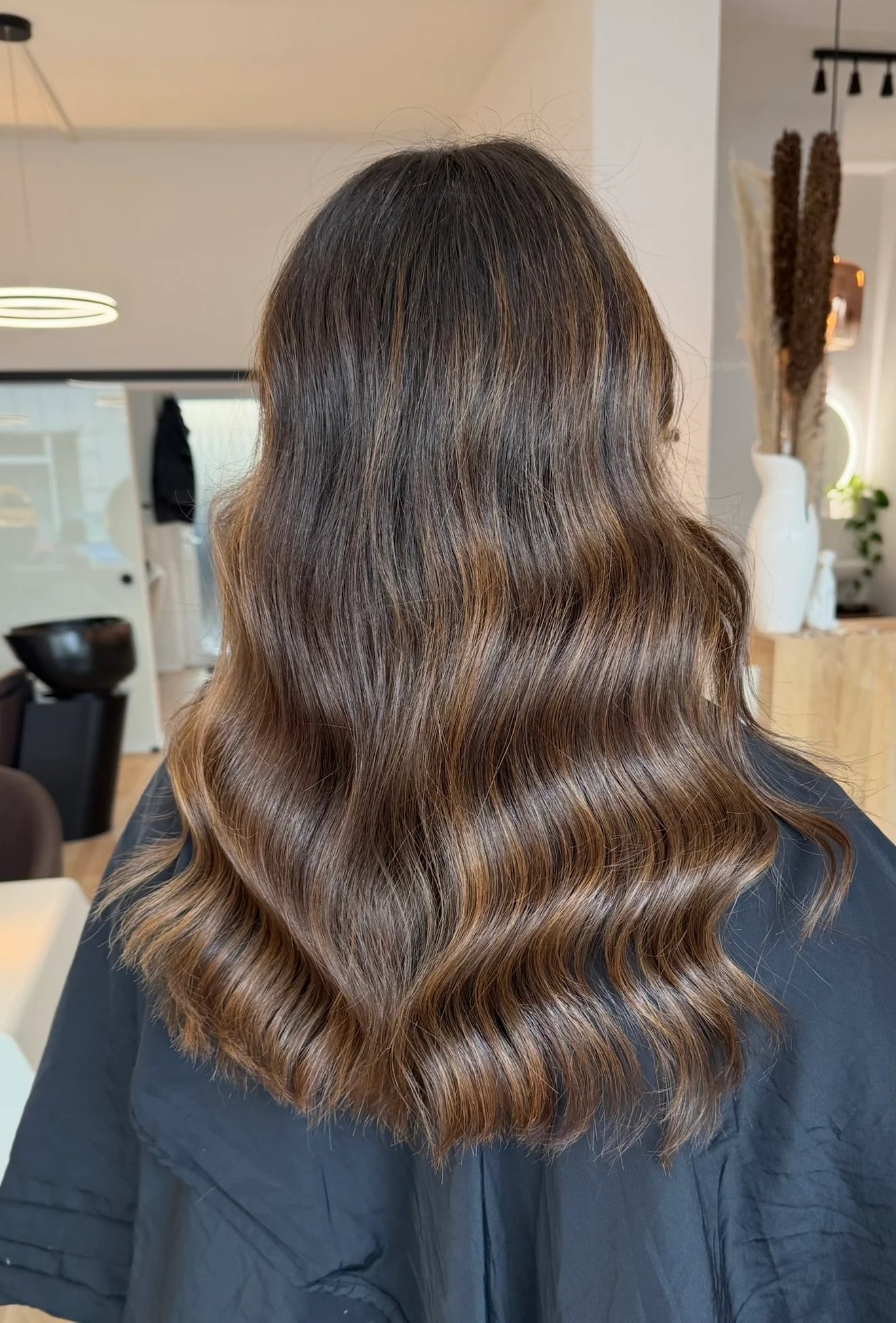 Langes braunes Haar mit glänzenden Wellen bei her art.